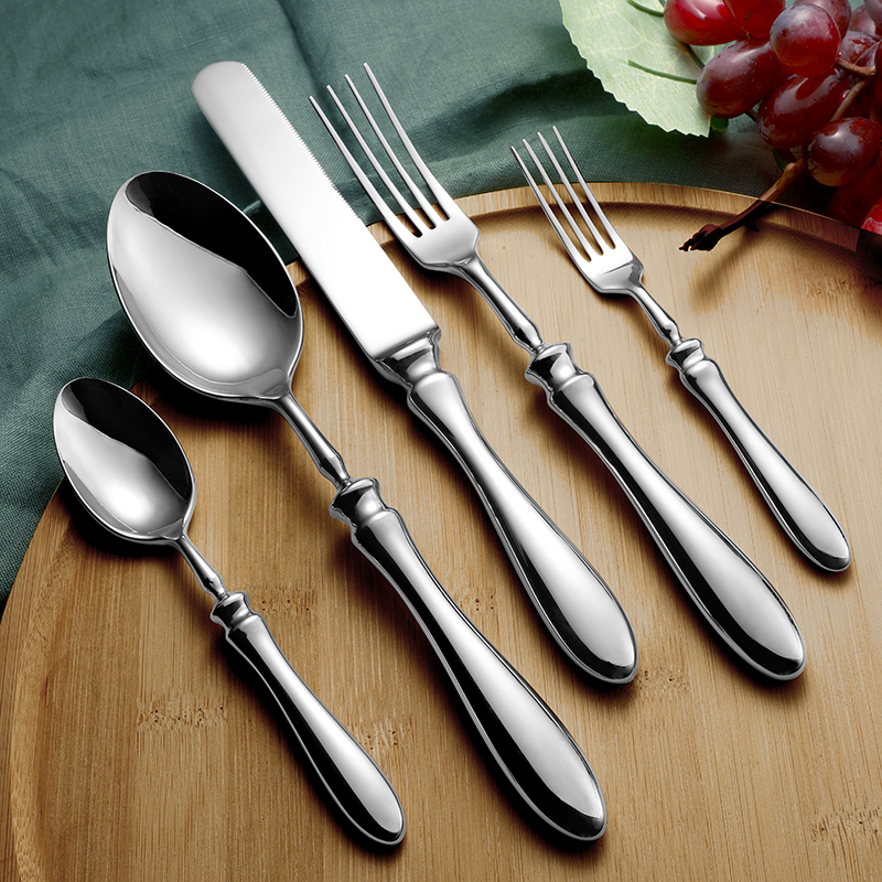 A detailed close-up of the fourth flatware set, focusing on the intricate patterns on the handles.