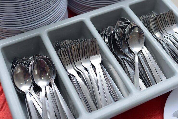 A neat wooden drawer organizer with different types of cutlery in their own compartments