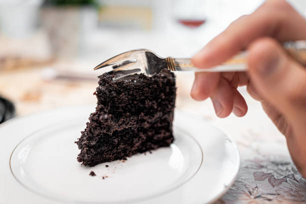 A person elegantly eating a slice of cake with only a small cake fork, no knife needed
