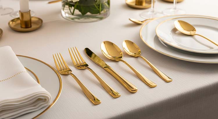A set of gleaming gold electroplate flatware arranged elegantly on a dinner table