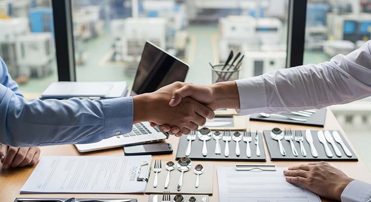 A handshake between a client and a factory owner in a modern cutlery showroom
