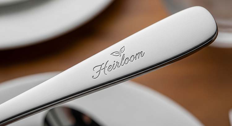 A steel die pressing a logo into the handle of a spoon
