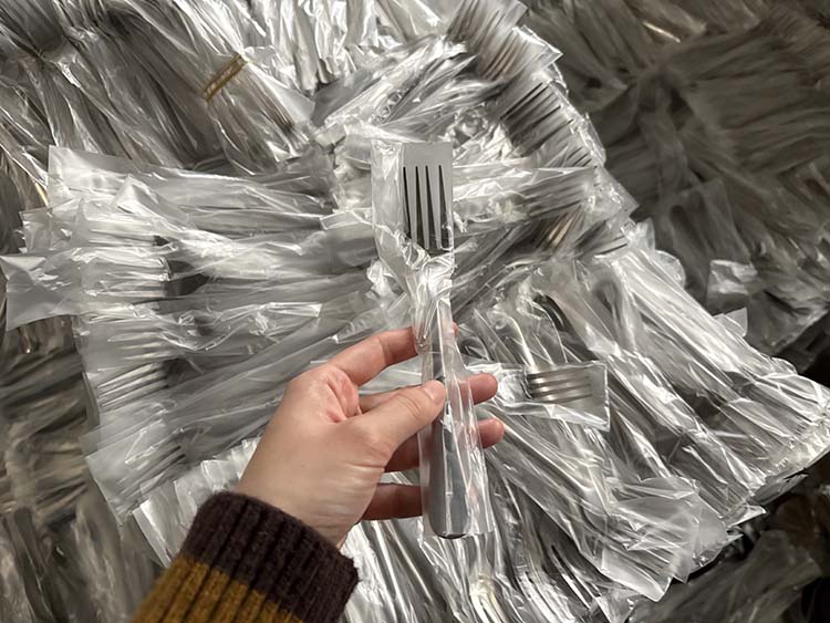Bulk packed stainless steel spoons in a large shipping carton