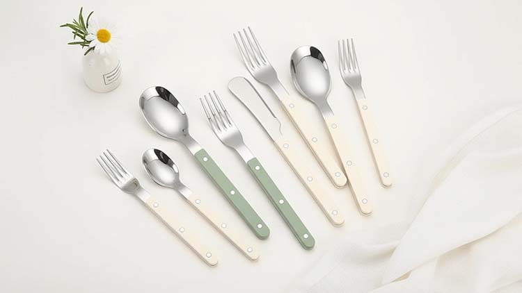 A classic shot of the W004 cutlery, perhaps showing both green and beige handle options, on a checkered tablecloth to evoke a bistro feel.
