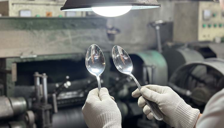 A close-up shot under bright light showing an inspector comparing the shine on two spoons