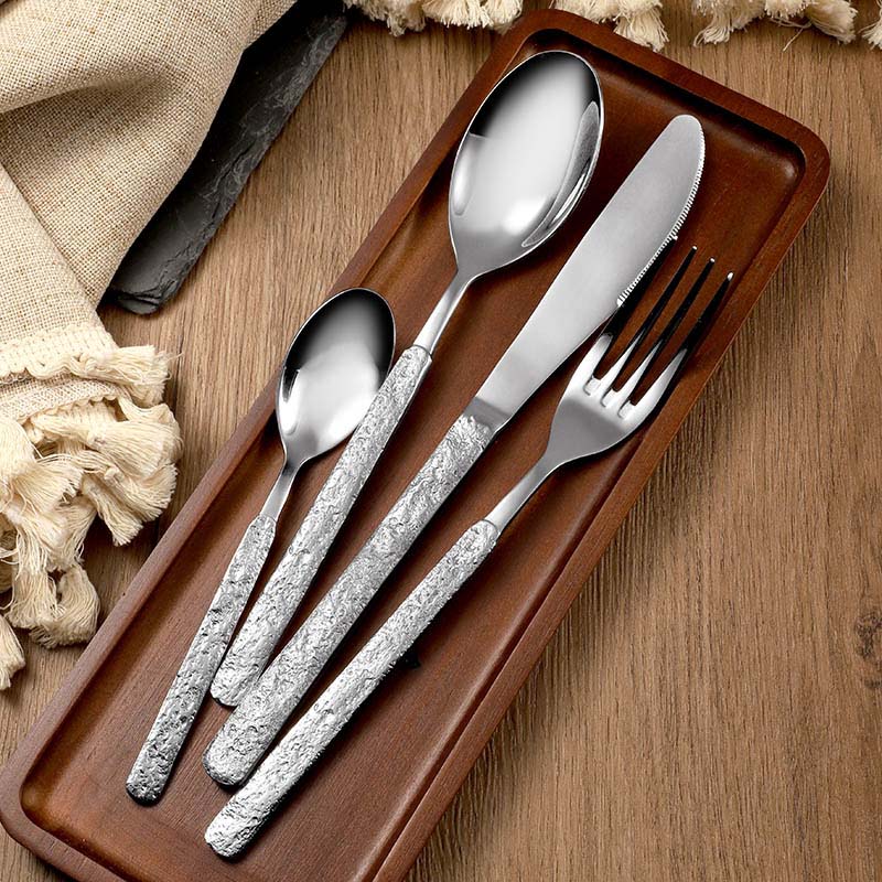 Textured stone pattern detail on stainless steel spoon fork knife set