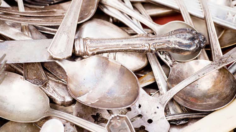 A close-up image showing the worn-off silver plating on a fork, revealing the yellowish base metal underneath