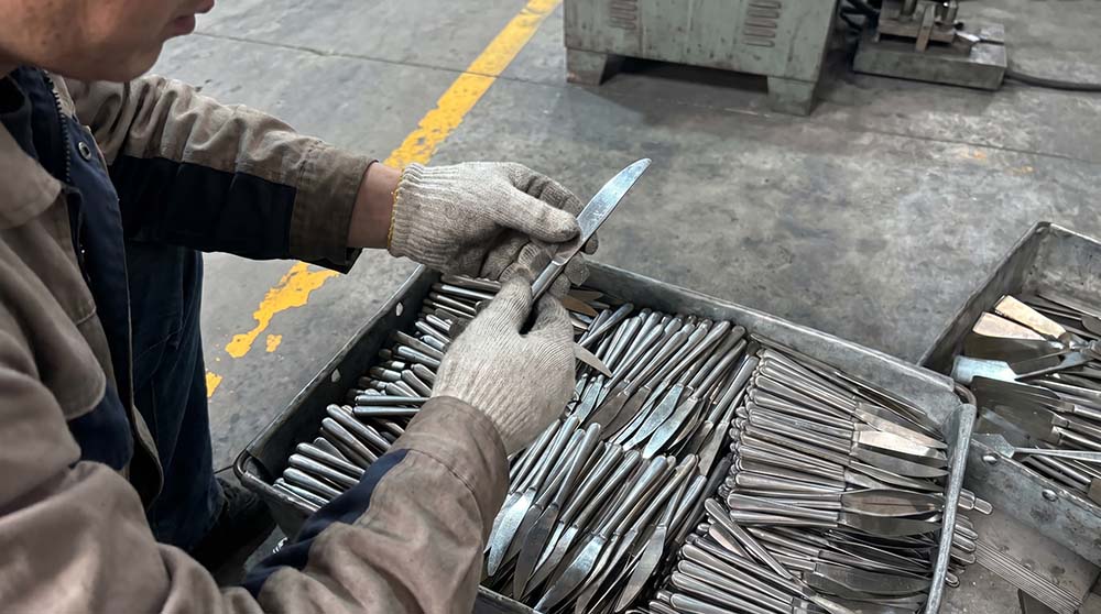 Cutlery Sample Inspection A quality control expert inspecting a newly molded spoon