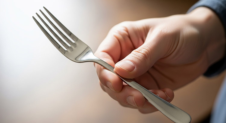 Hand Feel and Smoothness of Polished Flatware A close-up of a person's hand holding a smoothly polished fork