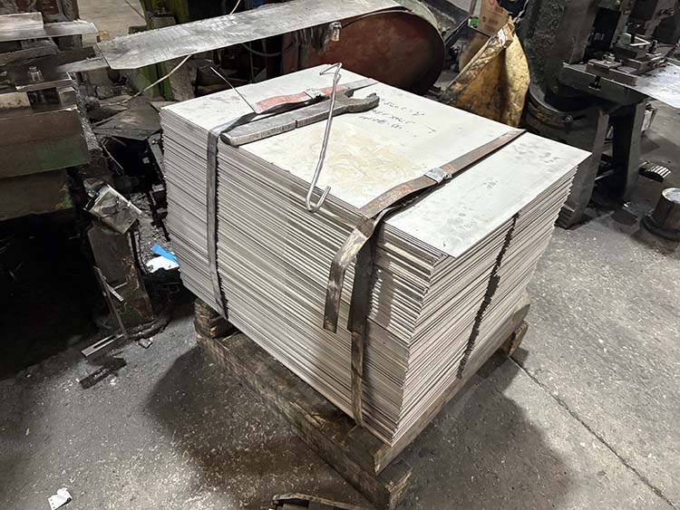 A machine cutting a large sheet of stainless steel