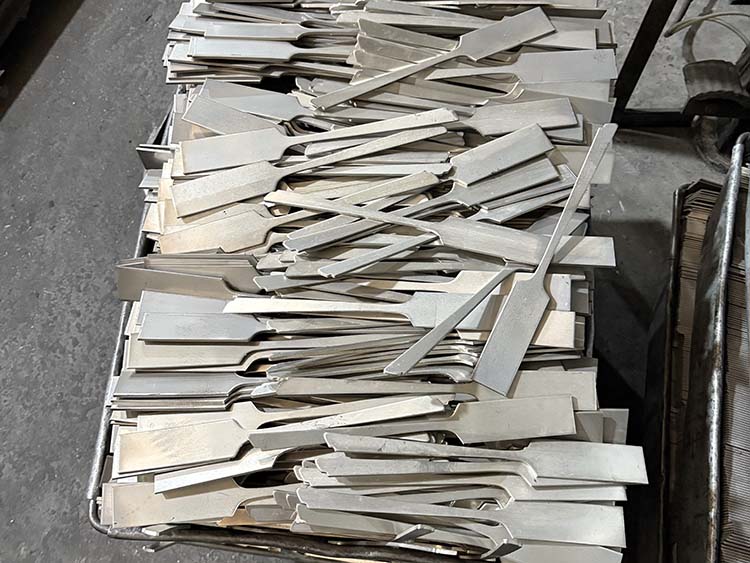 A stamping machine punching out fork shapes from a steel sheet
