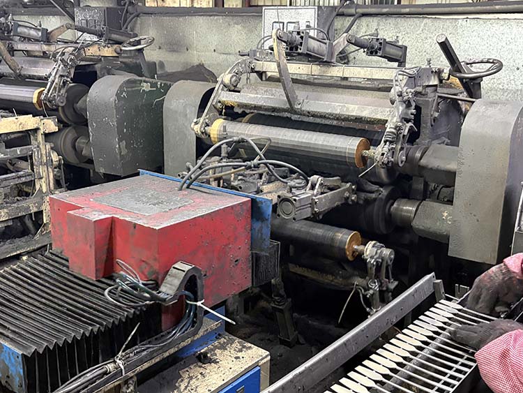 A machine performing flat polishing on stainless steel spoons