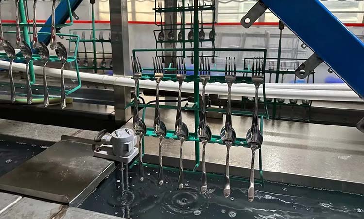 Stainless steel flatware being cleaned in an industrial washing machine