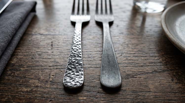 close up on the handle of a hammered finish fork and a stone wash finish knife