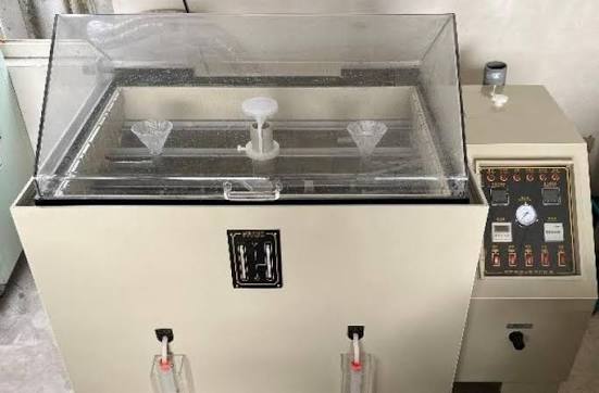 A close-up of stainless steel spoons undergoing salt spray testing in a controlled chamber